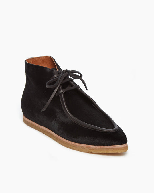 Angled side view of the Coclico Quinn Boot sophisticated chukka bootie in our limited edition black lux hair. Gentilly pointed moc toe, raised black leather piping and lace closure. Inside you'll discover a 30MM hidden wedge that adds height and comfort. 