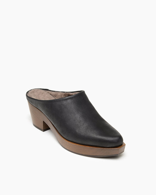 A black leather mule with a tapered toe, a wooden block heel, and a slightly cushioned interior lining.