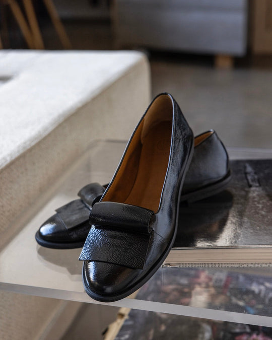 Yale Loafer in Black Patent placed on an acrylic table. 