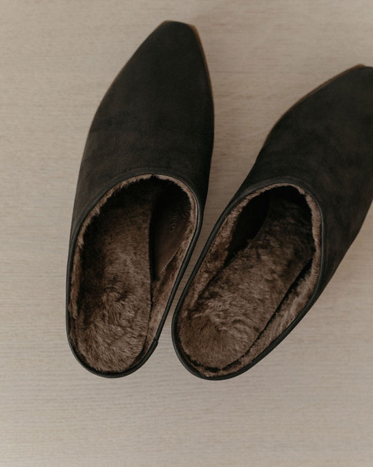 Top view of the Kera Shearling Clog in Black against a wooden backdrop. 